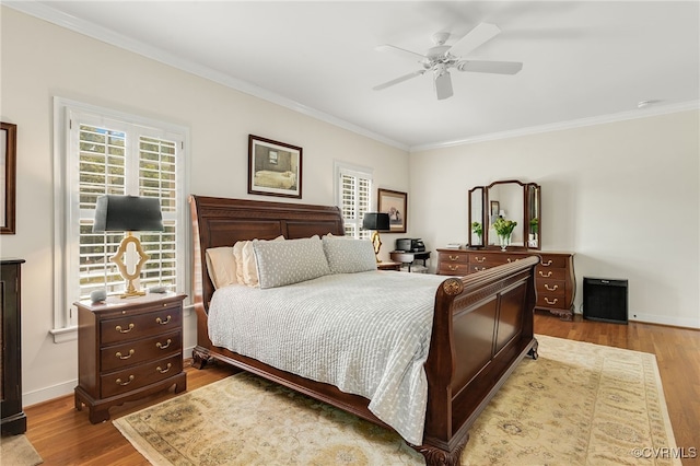 bedroom featuring crown molding, baseboards, and wood finished floors