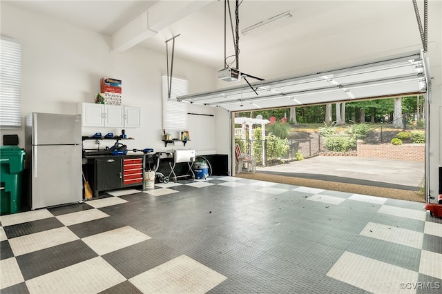 garage with a garage door opener and freestanding refrigerator