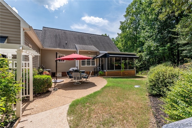 back of property with a patio, a yard, a sunroom, a shingled roof, and entry steps