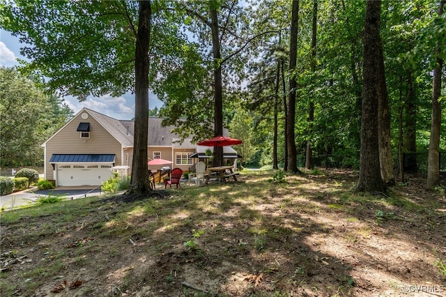 view of yard with concrete driveway and a garage