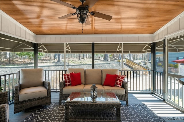 interior space with outdoor lounge area and ceiling fan