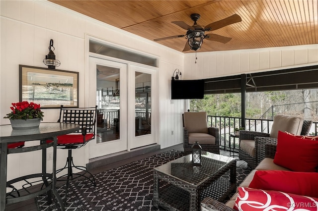 sunroom featuring wooden ceiling and a ceiling fan