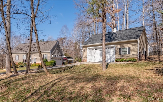 view of yard with concrete driveway and fence