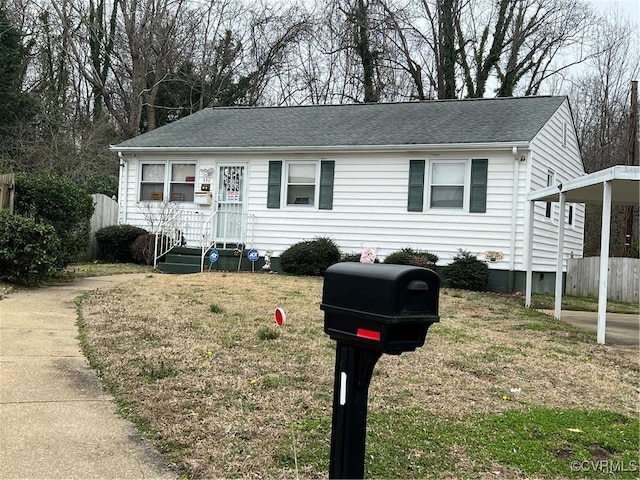 single story home featuring a carport, roof with shingles, a front yard, and fence