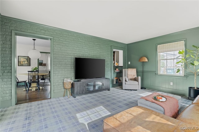 living room featuring brick wall and wainscoting