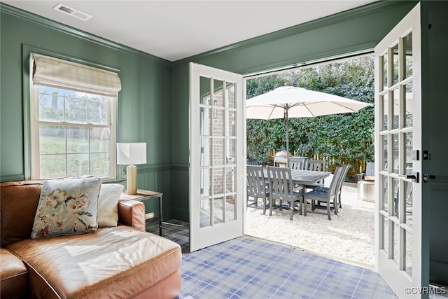 living area with visible vents, french doors, and ornamental molding