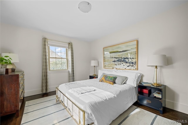 bedroom with wood finished floors and baseboards