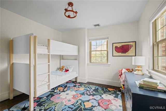 bedroom with visible vents, dark wood-type flooring, and baseboards