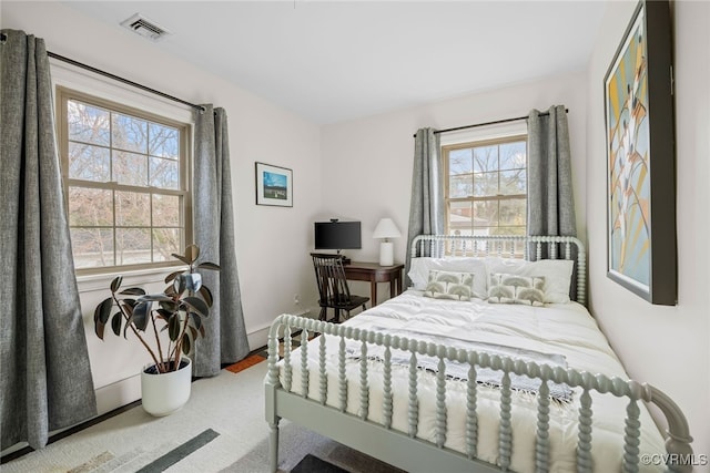 carpeted bedroom featuring visible vents