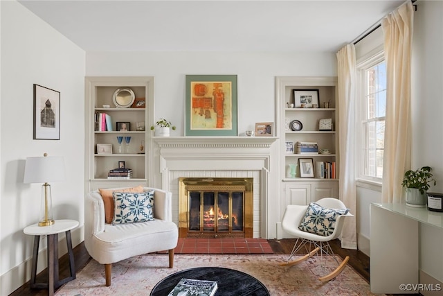 living area with built in features, a fireplace, and baseboards