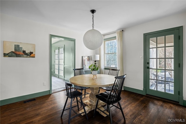 dining area with dark wood-style floors, visible vents, and baseboards