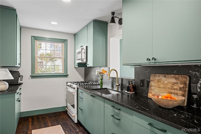 kitchen with white gas range, a sink, decorative backsplash, and green cabinetry