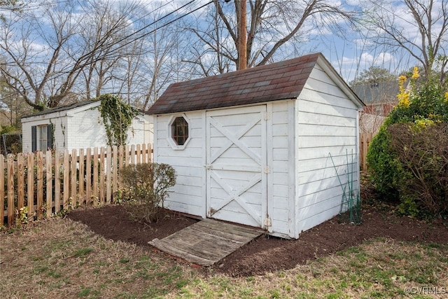 view of shed featuring fence