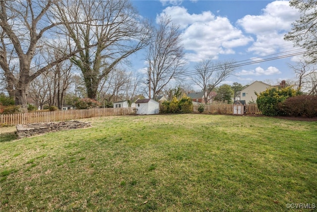 view of yard with an outdoor structure, fence private yard, and a shed