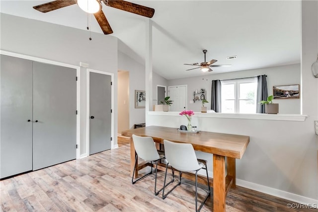 dining space with visible vents, ceiling fan, lofted ceiling, and wood finished floors