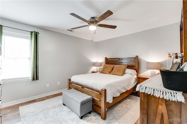 bedroom with visible vents, a ceiling fan, light wood-style floors, and baseboards