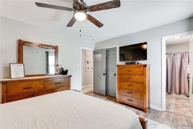 bedroom with ceiling fan, baseboards, and light wood-style floors