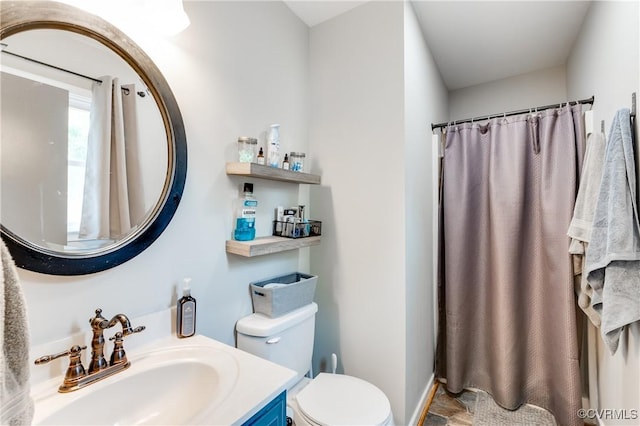 bathroom featuring vanity, curtained shower, and toilet