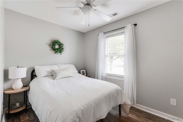 bedroom with visible vents, a ceiling fan, dark wood-type flooring, and baseboards