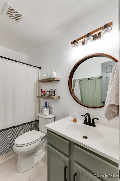 bathroom with visible vents, curtained shower, toilet, and vanity