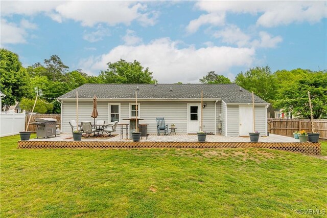 back of property with fence, a lawn, and a wooden deck