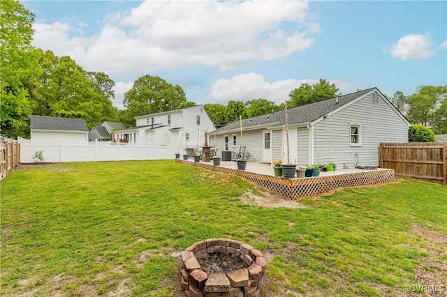 back of house with a deck, a yard, a fenced backyard, and a fire pit