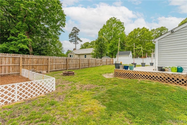 view of yard with a fire pit, a wooden deck, and a fenced backyard