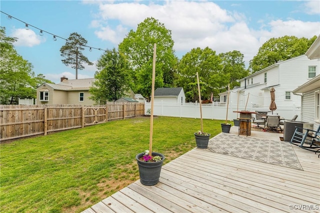 wooden terrace with a fenced backyard and a lawn