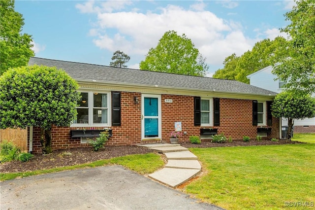 ranch-style home featuring a front yard, brick siding, and roof with shingles