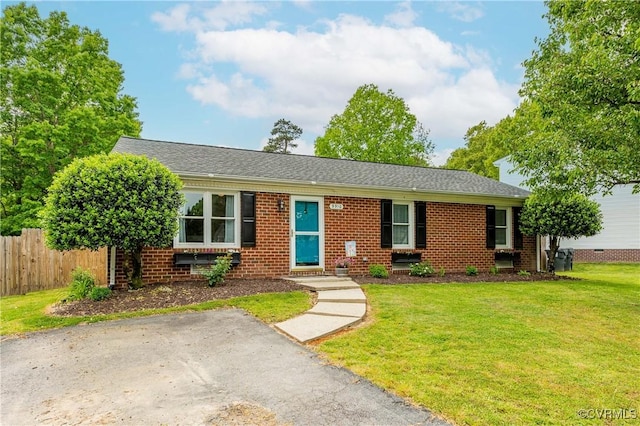 single story home with a front lawn, fence, brick siding, and a shingled roof