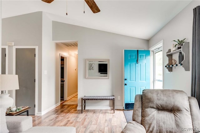 living area featuring visible vents, baseboards, light wood-type flooring, vaulted ceiling, and a ceiling fan