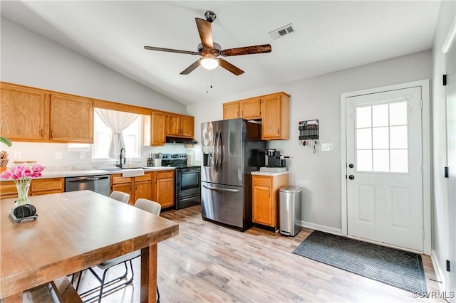 kitchen featuring visible vents, a sink, under cabinet range hood, stainless steel appliances, and light countertops