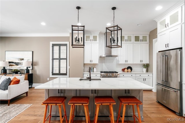 kitchen featuring high end fridge, a breakfast bar, ornamental molding, a sink, and stove