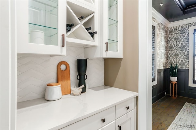 kitchen featuring ornamental molding, white cabinetry, wallpapered walls, glass insert cabinets, and light countertops