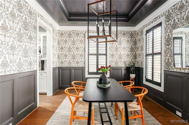 dining space with crown molding, wainscoting, and wallpapered walls