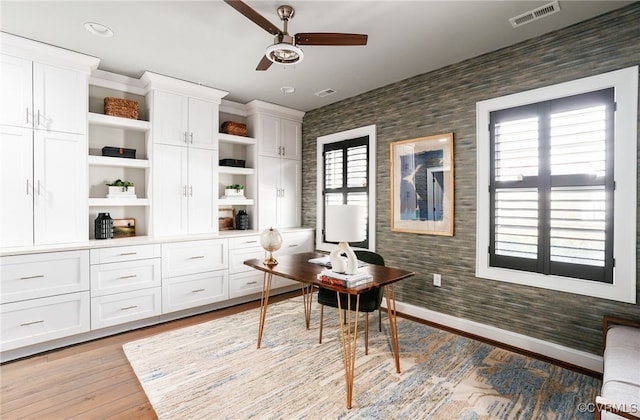 office with visible vents, a healthy amount of sunlight, wallpapered walls, and light wood-style flooring