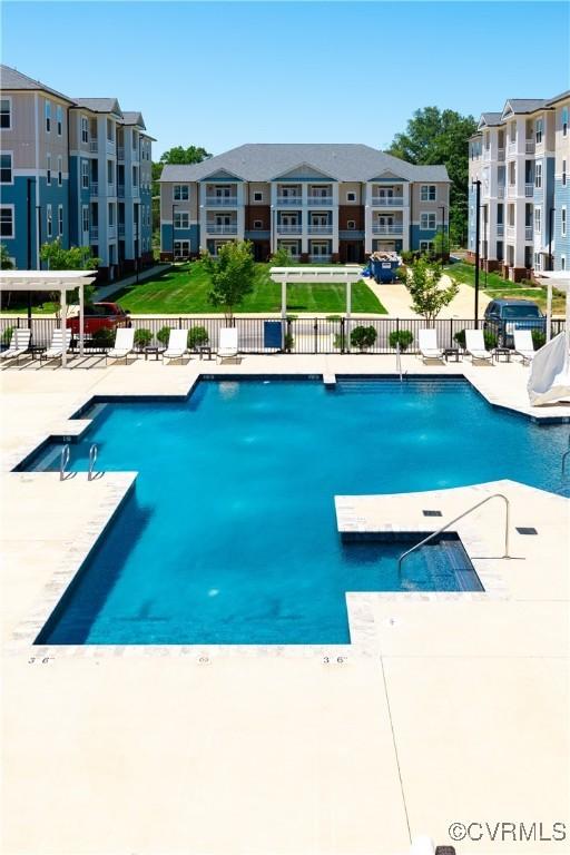 pool with a patio area and fence