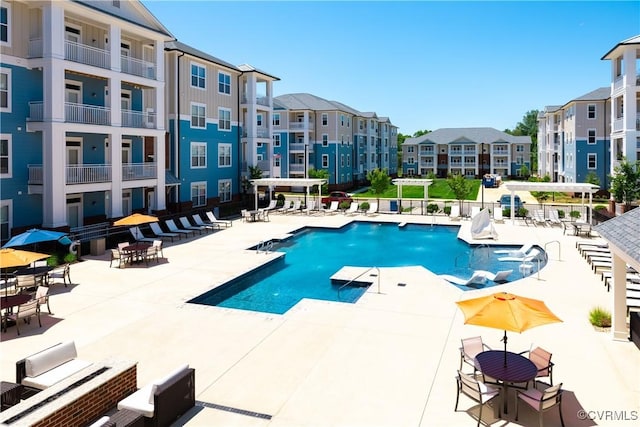 community pool with a patio area and a residential view