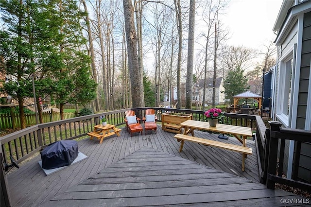 wooden deck with a gazebo, a grill, and fence