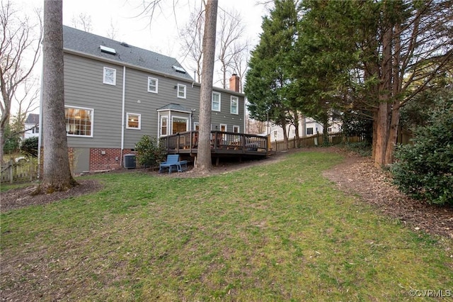 back of property with a lawn, central AC, fence, a wooden deck, and a chimney