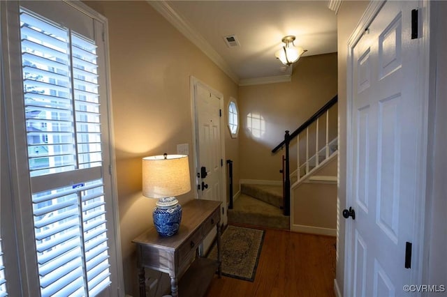 entrance foyer with visible vents, crown molding, baseboards, stairs, and wood finished floors