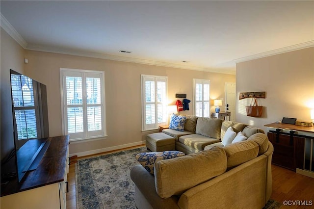 living room with baseboards, wood finished floors, visible vents, and ornamental molding