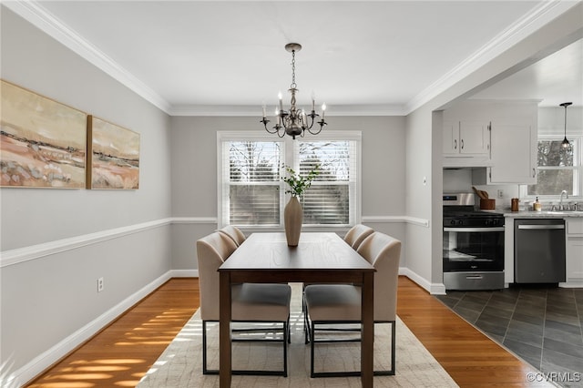 dining room with crown molding, dark wood-style floors, baseboards, and a chandelier