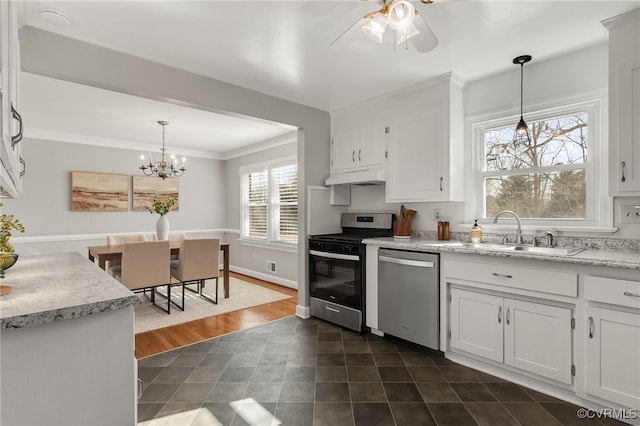 kitchen with a sink, hanging light fixtures, stainless steel appliances, white cabinets, and under cabinet range hood