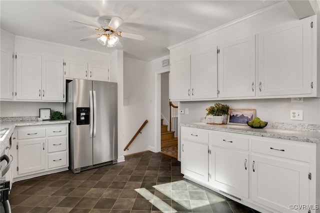 kitchen featuring white cabinetry, a ceiling fan, stainless steel fridge, and light stone countertops