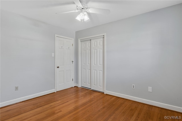 unfurnished bedroom featuring a closet, baseboards, light wood-style floors, and a ceiling fan