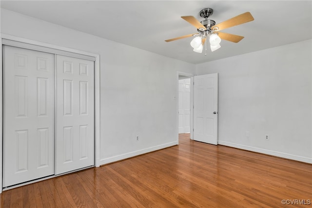 unfurnished bedroom with a closet, a ceiling fan, baseboards, and wood finished floors