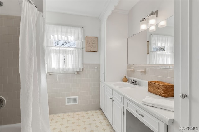 bathroom featuring tile patterned floors, visible vents, a shower with shower curtain, tile walls, and vanity