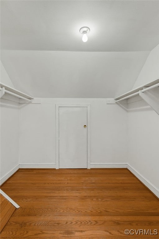 walk in closet featuring vaulted ceiling and wood finished floors