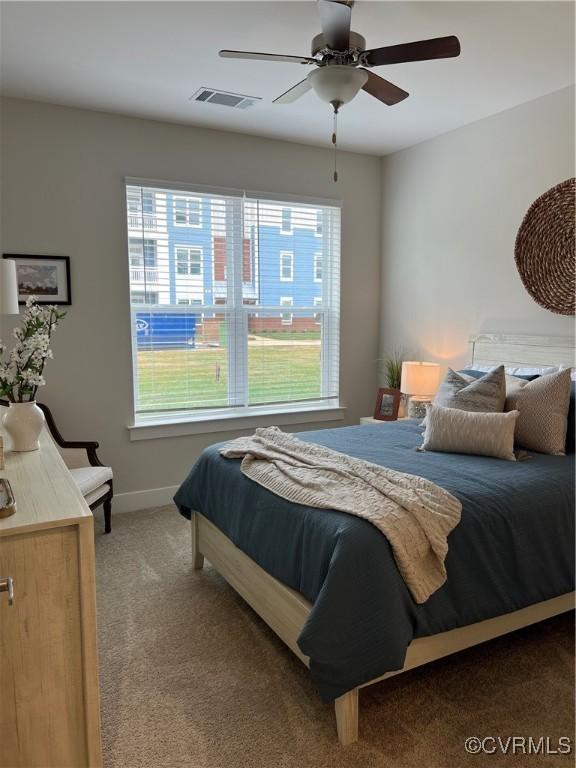 carpeted bedroom featuring a ceiling fan, baseboards, and visible vents